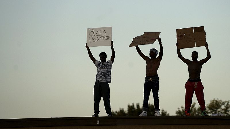 Manifestantes sostienen pancartas con el lema "Las vidas negras importan"