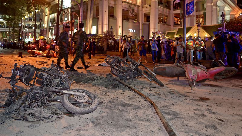 Un policía tailandés mira el cráter presumiblemente causado por la explosión