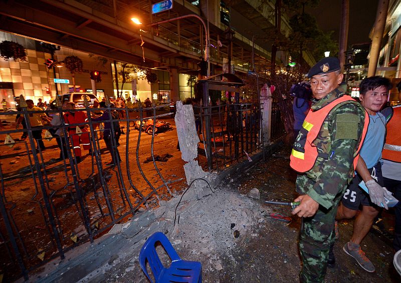 Un policía tailandés mira el cráter presumiblemente causado por la explosión