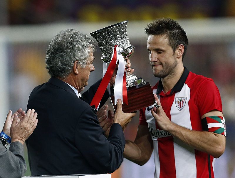 El capitán del Athletic Club Carlos Gurpegi  recibe el trofeo de Supercopa de manos del presidente de la Real Federación Española de Fútbol Ángel María Villar.