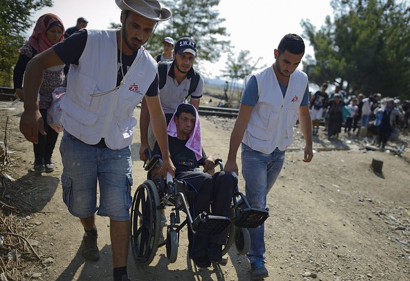 Miembros de Médicos sin Fronteras ayudan a un refugiado a cruzar a Macedonia