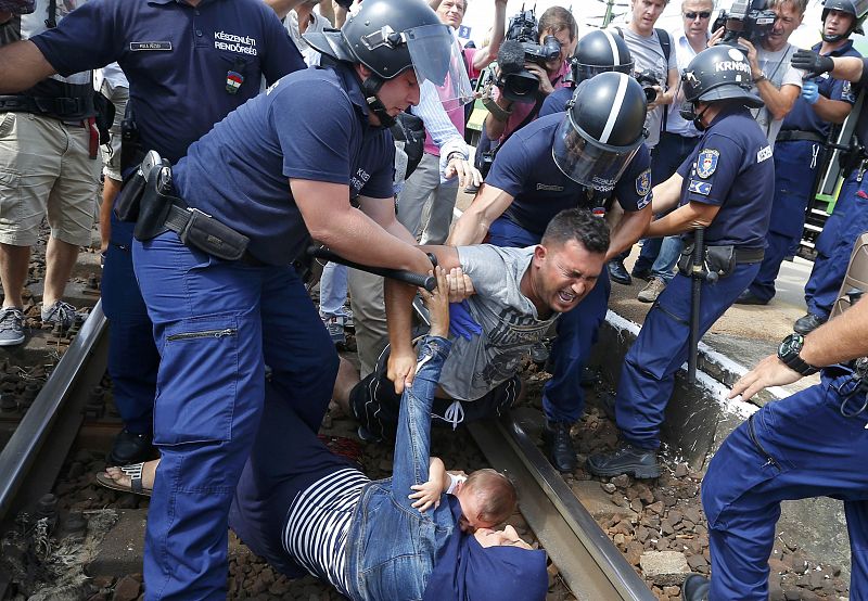 La policía húngara detiene a un migrante en la estación ferroviaria de Bickse