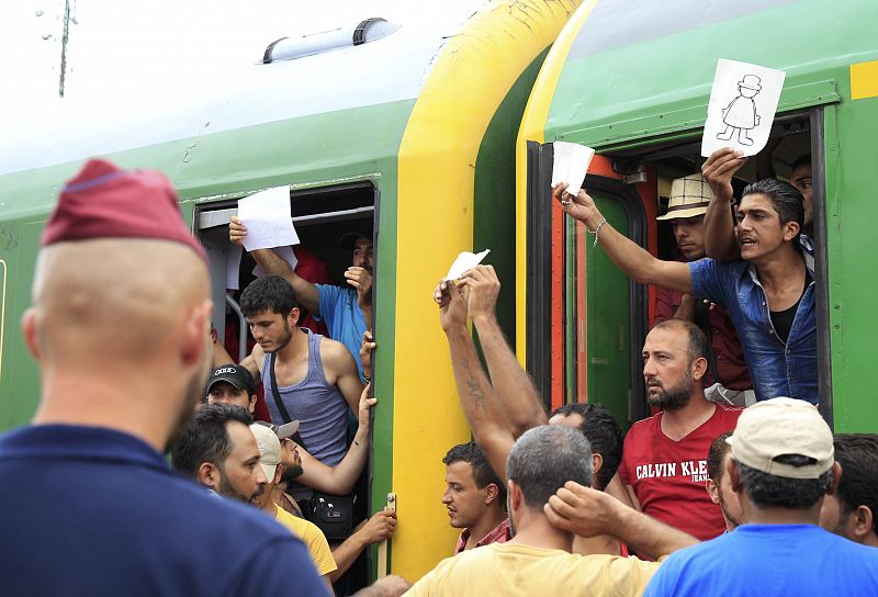 Migrantes protestan desde el tren  en la estación de Bickse para evitar ser registrados por la policía húngara