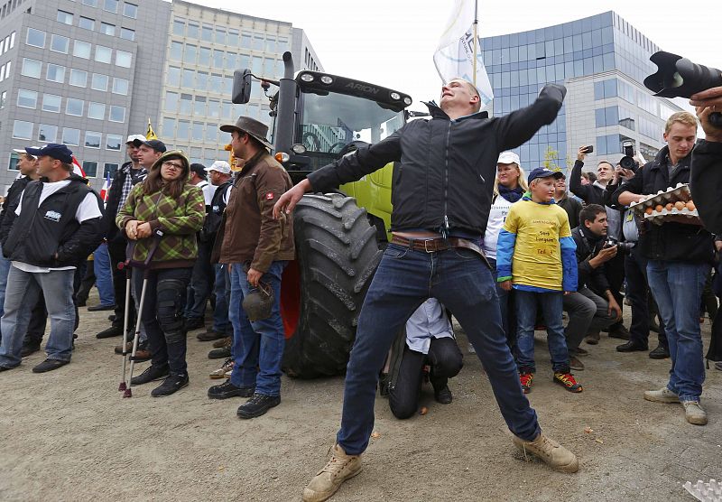 Un manifestante lanza huevos a los agentes antidisturbios en protesta por los bajos precios de la leche y otros productos