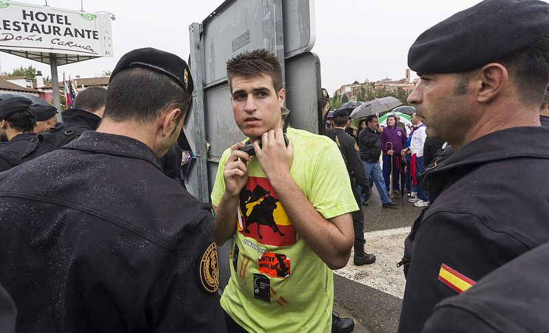 Miembros de la Guardia Civil junto a un joven que se ha encadenado el cuello en una señal de tráfico, durante la protesta contra el tradicional Toro de la Vega.