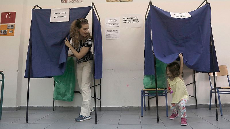 Una mujer acude a votar con su hija