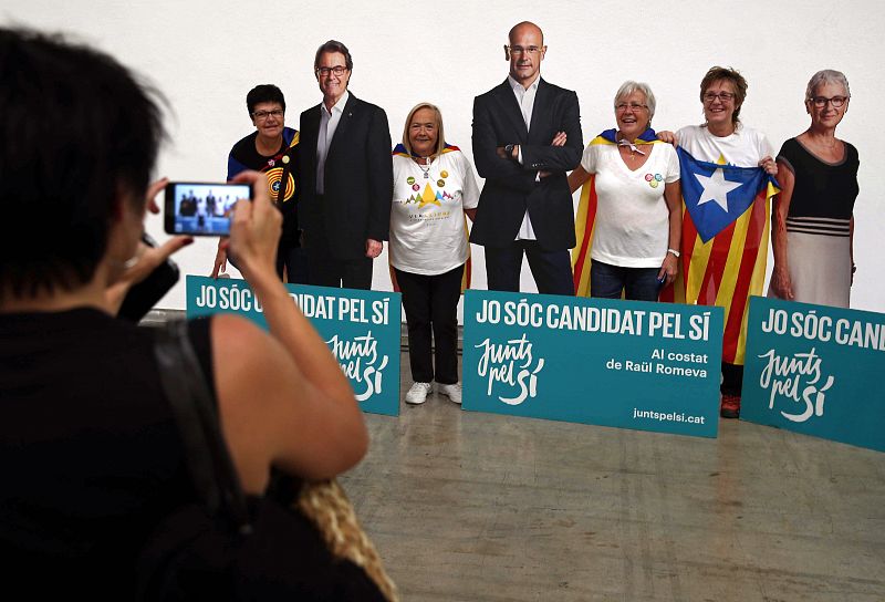 Asistentes al acto central de campaña de Junts pel Sí en la Farga de L'Hospitalet se fotografían con unas reproducciones de los candidatos Artur Mas, Raül Romeva y Muriel Casals a tamaño natural.
