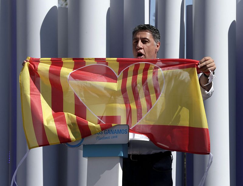 El candidato del PPC, Xavier García Albiol, muestra una bandera que une las de Cataluña y España, en un mitin en Badalona.