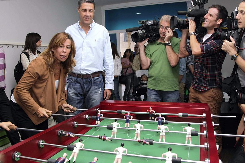 La presidenta del PPC, Alicia Sánchez Camacho, juega al futbolín -con dos equipos vestidos como el FC Barcelona y el Real Madrid- en presencia del candidato popular a la Generalitat, Xavier García Albiol, en una ludoteca en Barcelona.