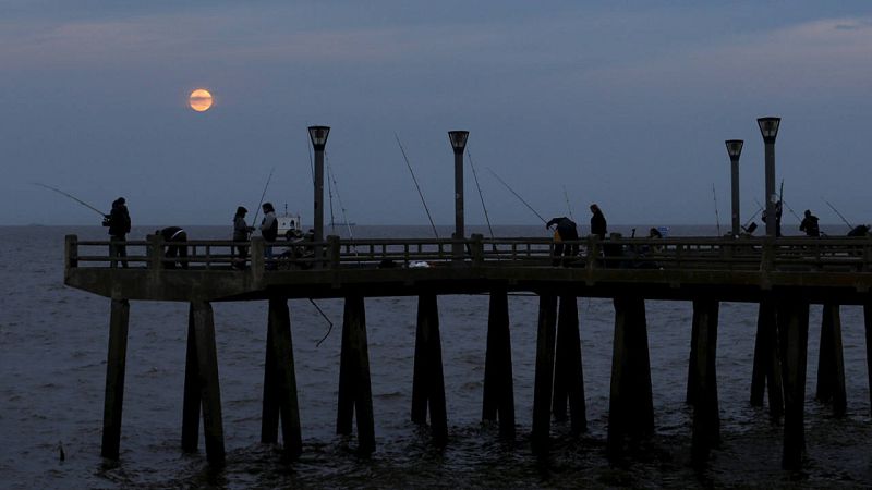 Un grupo de pescadores, ante la superluna, en la ciudad argentina de Buenos Aires.