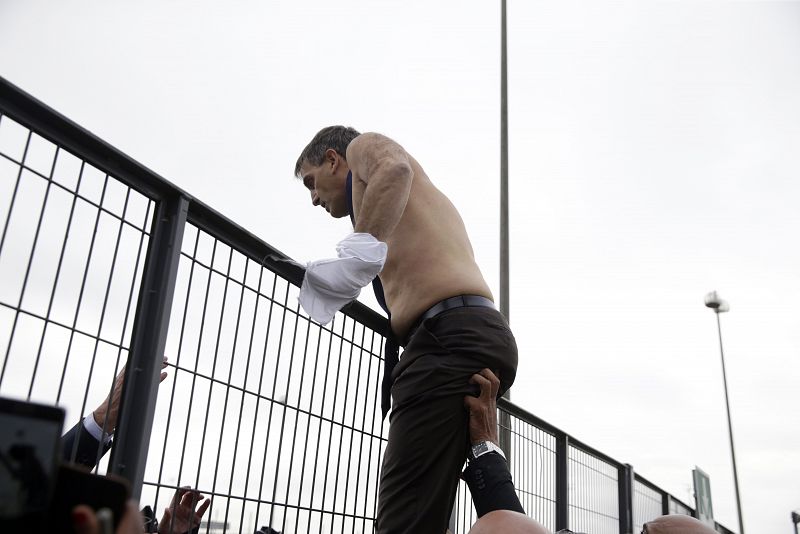 Agentes de seguridad ayudan al jefe de Recursos Humanos de Air France a saltar una valla en la sede de la aerolínea