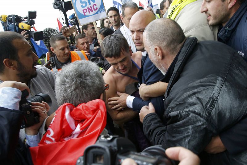 Xavier Broseta, Executive Vice President for Human Resources and Labour Relations at Air France, is evacuated by security after employees interrupted a meeting at the Air France headquarters building in Roissy