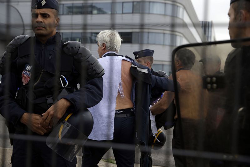 El director de Air France en el aeropuerto de Orly y el jefe de Recursos Humanos se alejan de la multitud escoltados