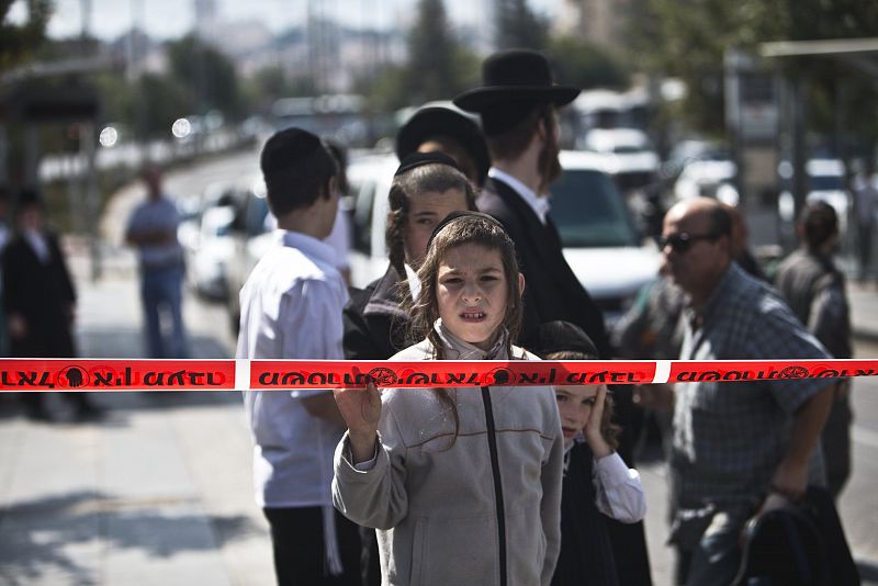 Un niño israelí observa tras la línea policial en la escena del apuñalamiento de un estudiante judío en Jerusalén