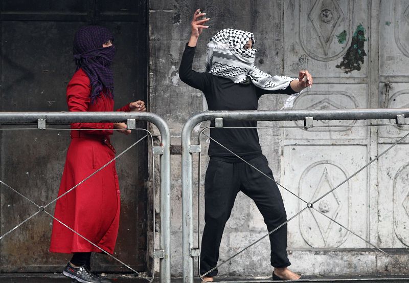 Una mujer palestina lanza piedras contra los soldados israelíes durante los enfrentamientos en la localidad de Hebrón