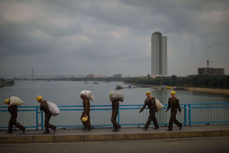 Obreros norcoreanos transportan sacos en las proximidades del hotel Yanggkado en Pyongyang