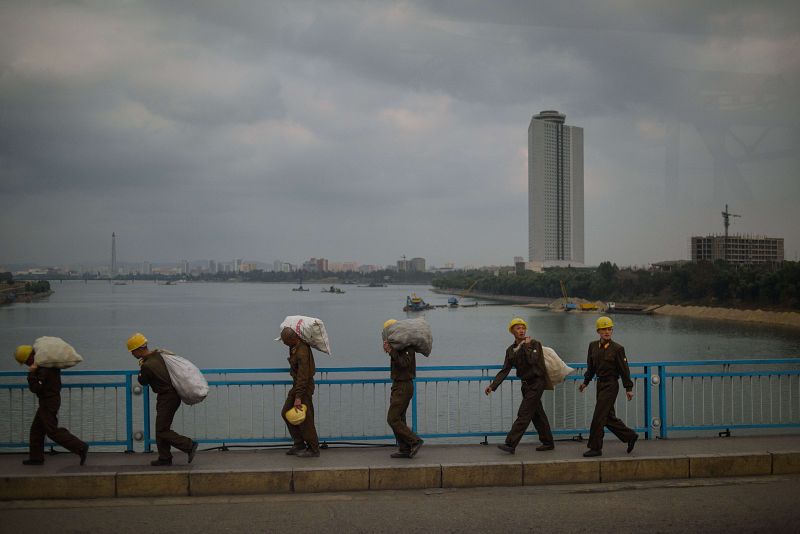 Obreros norcoreanos transportan sacos en las proximidades del hotel Yanggkado en Pyongyang