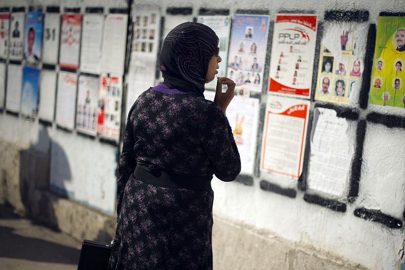 Una mujer tunecina contempla fotografías de los candidatos en campaña para las elecciones de 2011