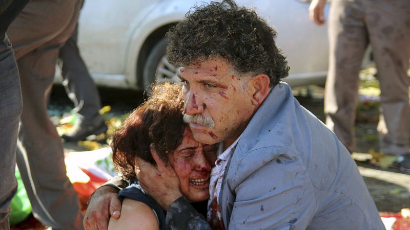 Un hombre herido abraza a una mujer tras los atentados en Ankara