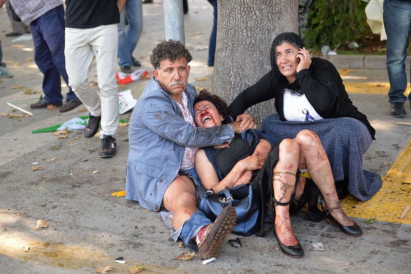 Dos personas atienden a una mujer que ha sido herida en el ataque