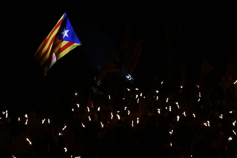 Una bandera estelada (símbolo del independentismo catalán) ondea sobre las antorchas en el homenaje a Lluís Companys en Montjuïc (Barcelona).