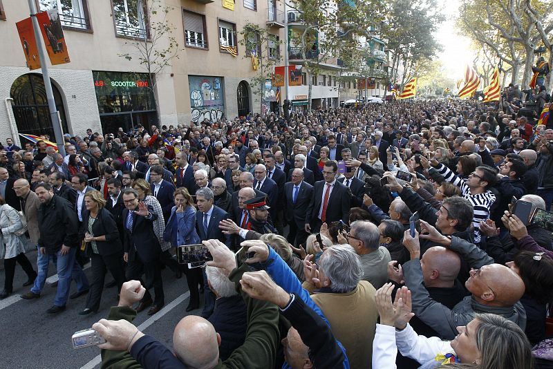 El presidente de la Generalitat, Artur Mas, saluda mientras se dirige a la Audiencia de Barcelona donde ha acudido esta mañana para declarar como imputado por el 9N, arropado por más de 400 alcaldes catalanes y cientos de ciudadanos.