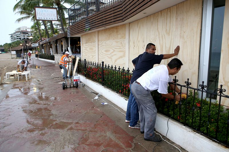 Habitantes de la zona turística de Puerto Vallarta protegen sus casas y comercios.
