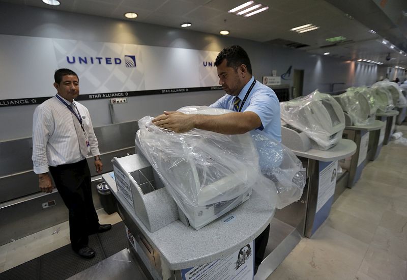 Empleados United Airlines cubren sus equipos en el aeropuerto internacional.