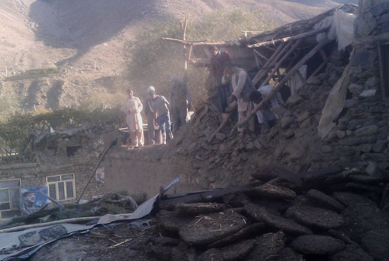 Varios afganos examinan las ruinas de una casa derruida por el terremoto en el distrito de Bazarak, en la provincia de Panjshir