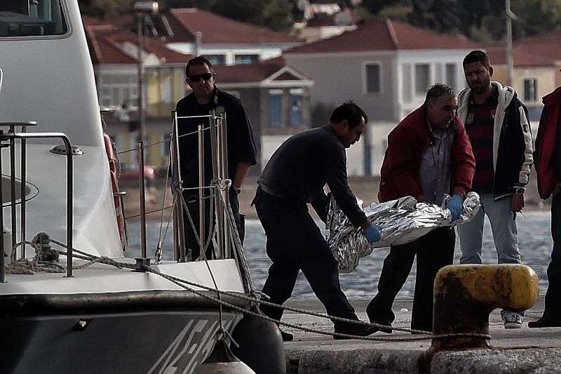 Un guardacostas y un empleado de la funeraria trasladan el cuerpo de uno de los fallecidos en el naufragio