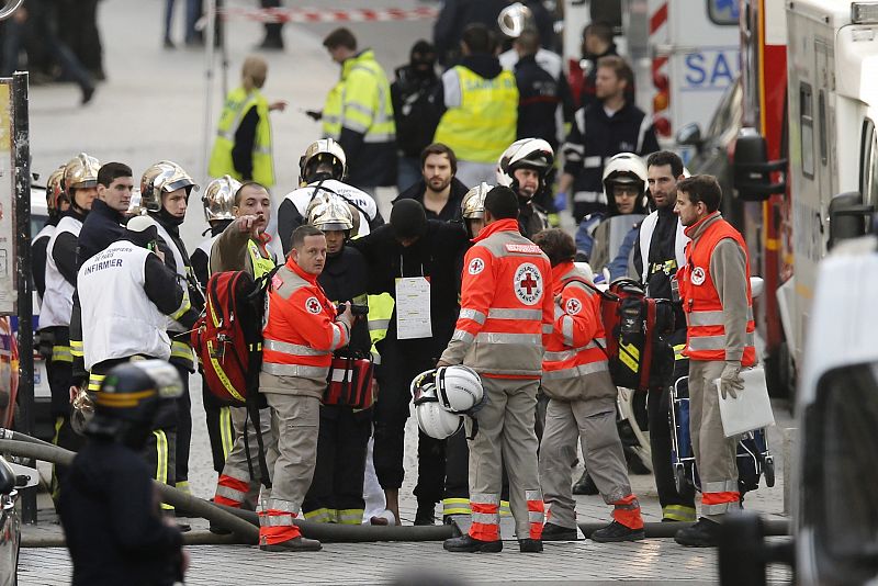 Personal médico asiste a un policía herido durante una operación en Saint Denis cerca de París (Francia). La Fiscalía de París confirmó que una mujer se suicidó haciendo estallar su cinturón de explosivos y otro terrorista más ha muerto. Al menos 7 p