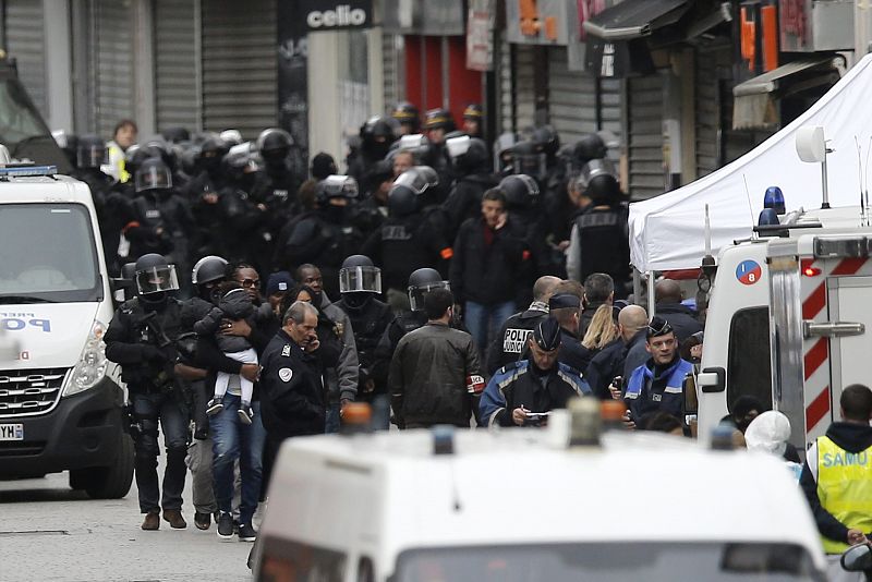 Vecinos de los edificios aledaños del piso asaltado por la policía en Saint Denis son evacuados al concluir la operación antiterrorista.