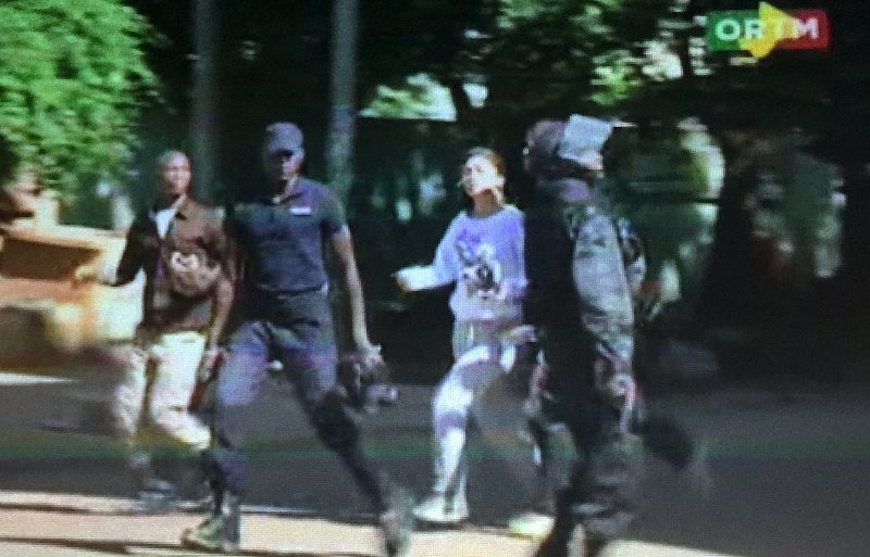 Still image from video show a hostage rushed out from the Radisson hotel in Bamako