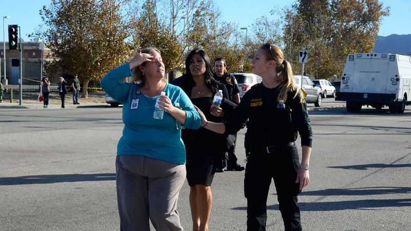 Una oficial de seguridad acompaña a algunas personas evacuadas