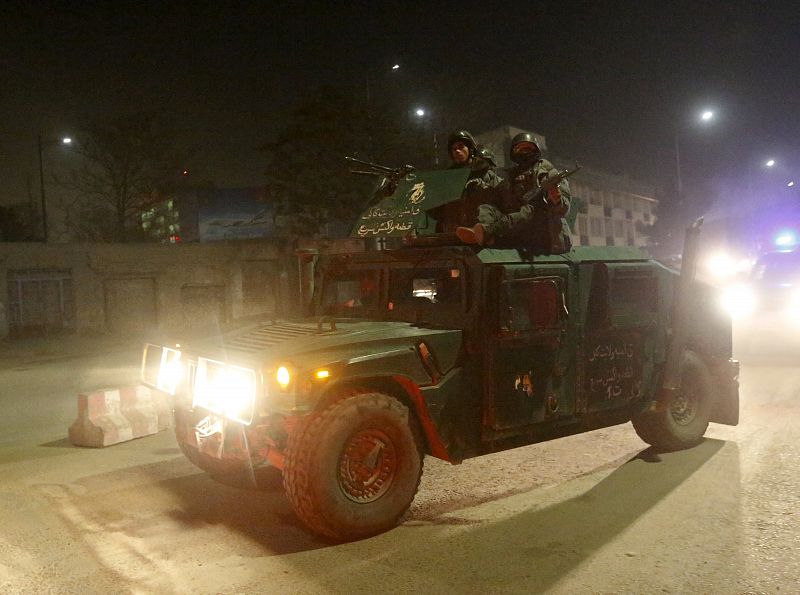 Policías afganos llegan en un vehículo tras la explosión y el tiroteo siguientes en Kabul.