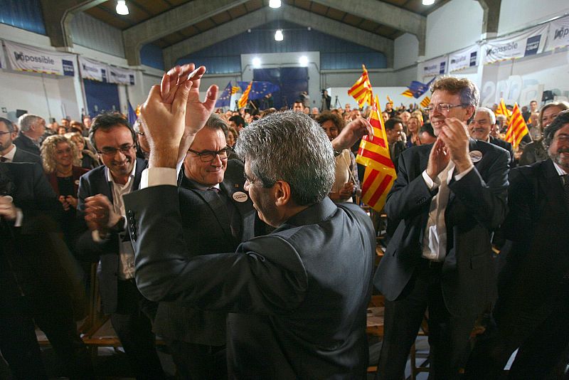 El presidente en funciones, Artur Mas, y el cabeza de lista al Congreso por Barcelona de Democrácia i LLibretat, Francesc Homs, se saludan al inicio del mitin final de campaña para las elecciones generales del 20D.