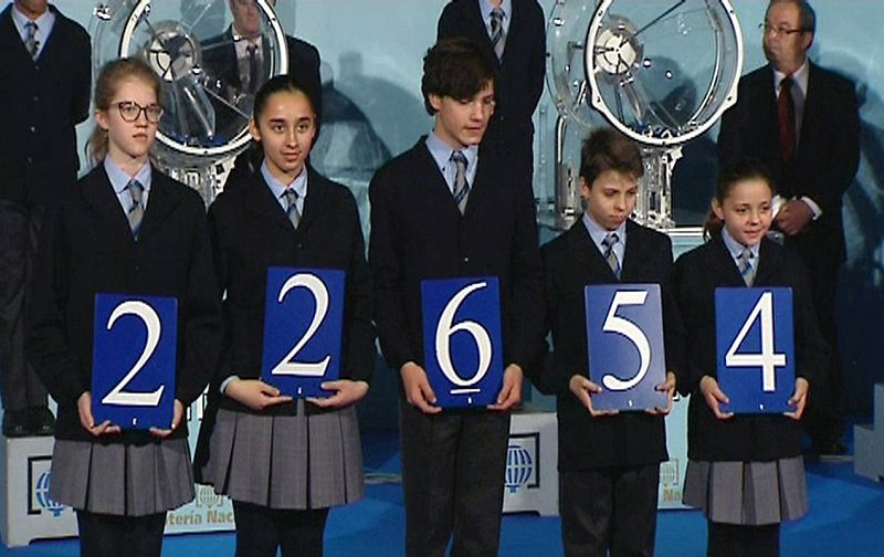 Los niños de San Ildefonso muestran el número 22.654, el primer premio del sorteo extraordinario de la lotería de El Niño, en el sorteo celebrado en el Círculo de Bellas Artes de Madrid. 