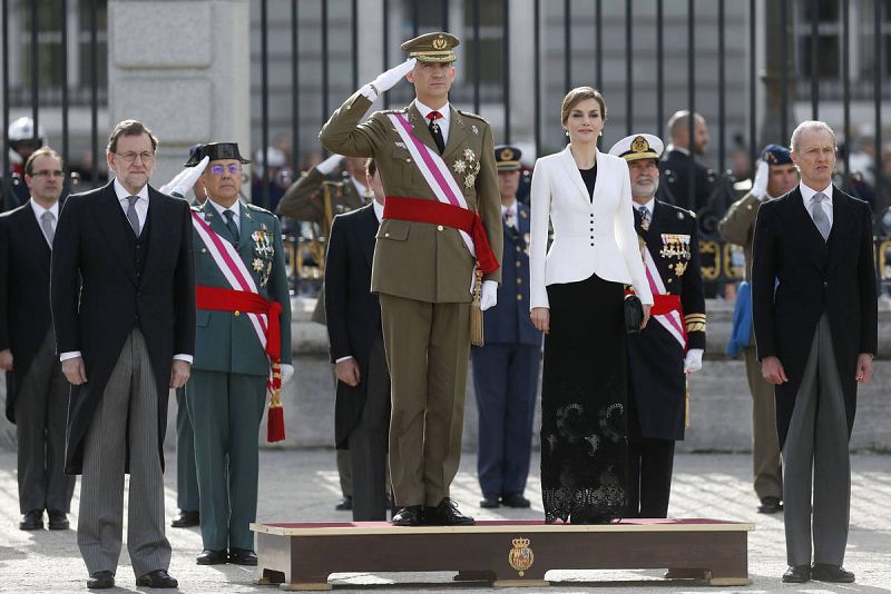 Los reyes, junto al presidente del Gobierno, Mariano Rajoy (i), y el ministro de Defensa, Pedro Morenés (d), escuchan el himno nacional durante la celebración de la Pascua Militar en el Patio de la Armería del Palacio Real de Madrid.