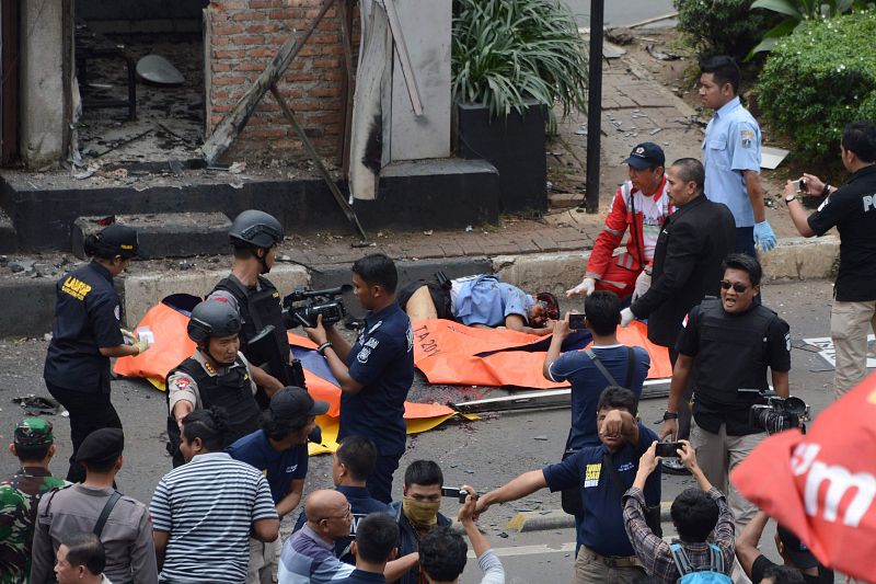 Los servicios de emergencia colocan bolsas sobre los cadáveres situados frente al puesto de policía que ha sido objeto de uno de los ataques