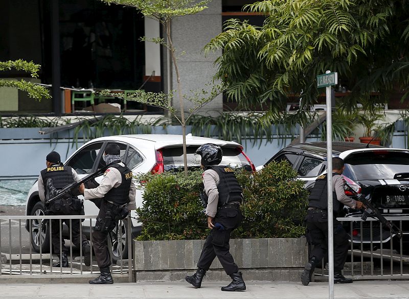 Agentes de la policía indonesia avanzan durante el tiroteo, mientras los asaltantes permanecen atrincherados