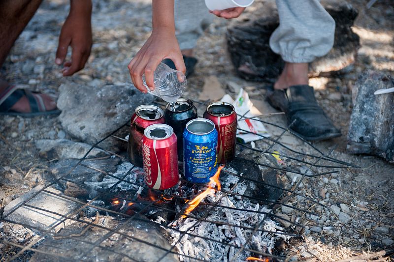 Refugiados sirios hierven te en latas vacías en el campo de Kara Tepe