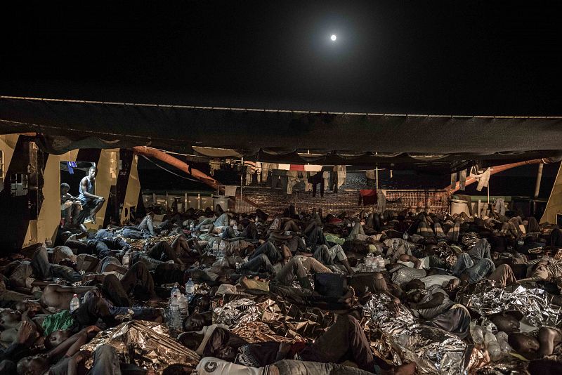 Migrantes rescatados por MSF duermen sobre la cubierta del barco