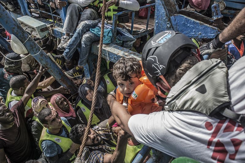 Un equipo de MSF saca a un niño de un barco ocupado por unas 650 personas.