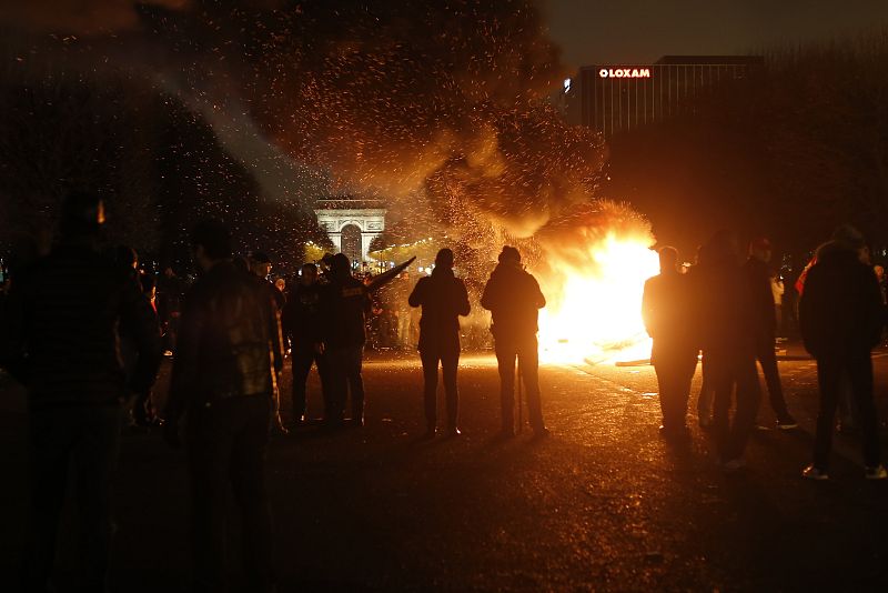 Taxistas en una barricada cercana al Arco del Triunfo al fondo