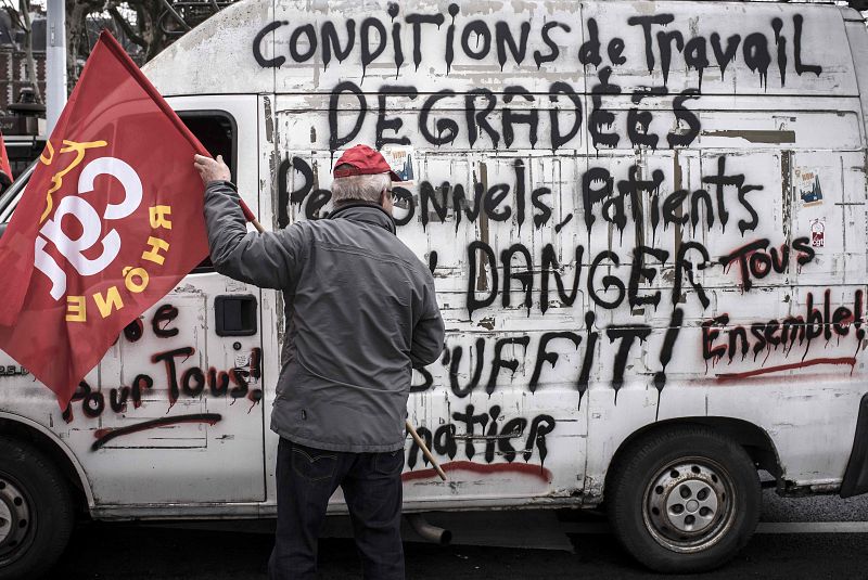 Un manifestante lee las consignas escritas en una furgoneta durante la manifestación de funcionarios en Lyon