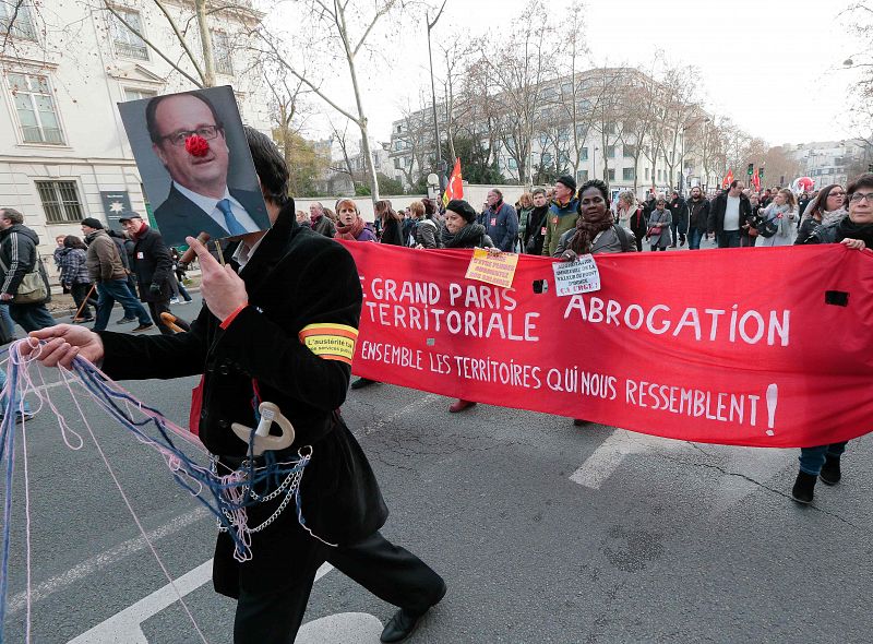 Un manifestante sostiene un retrato de Hollande con una nariz de payaso
