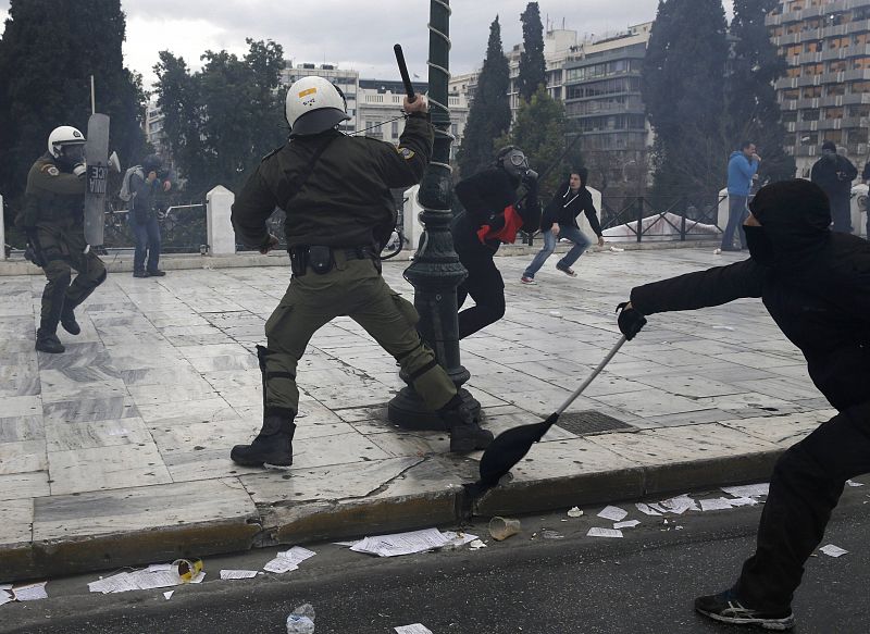 Masked demonstrators clash with a riot police during a 24-hour general strike against planned pension reforms in Athens