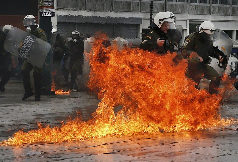 Riot police react to petrol bombs during a 24-hour general strike against planned pension reforms in Athens
