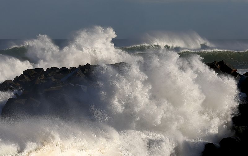 Una gran ola rompe contra el espigón de la playa de la Zurriola de San Sebastián.