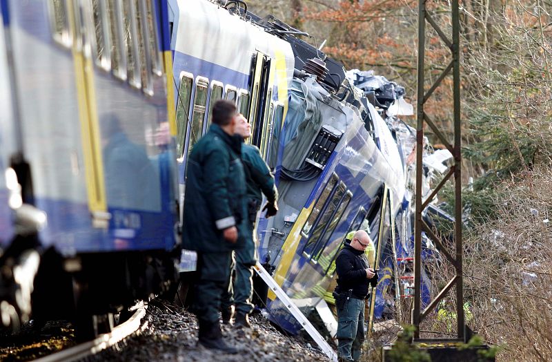 Un policía aguarda frente a uno de los trenes accidentados en Bad Aibling (Alemania)